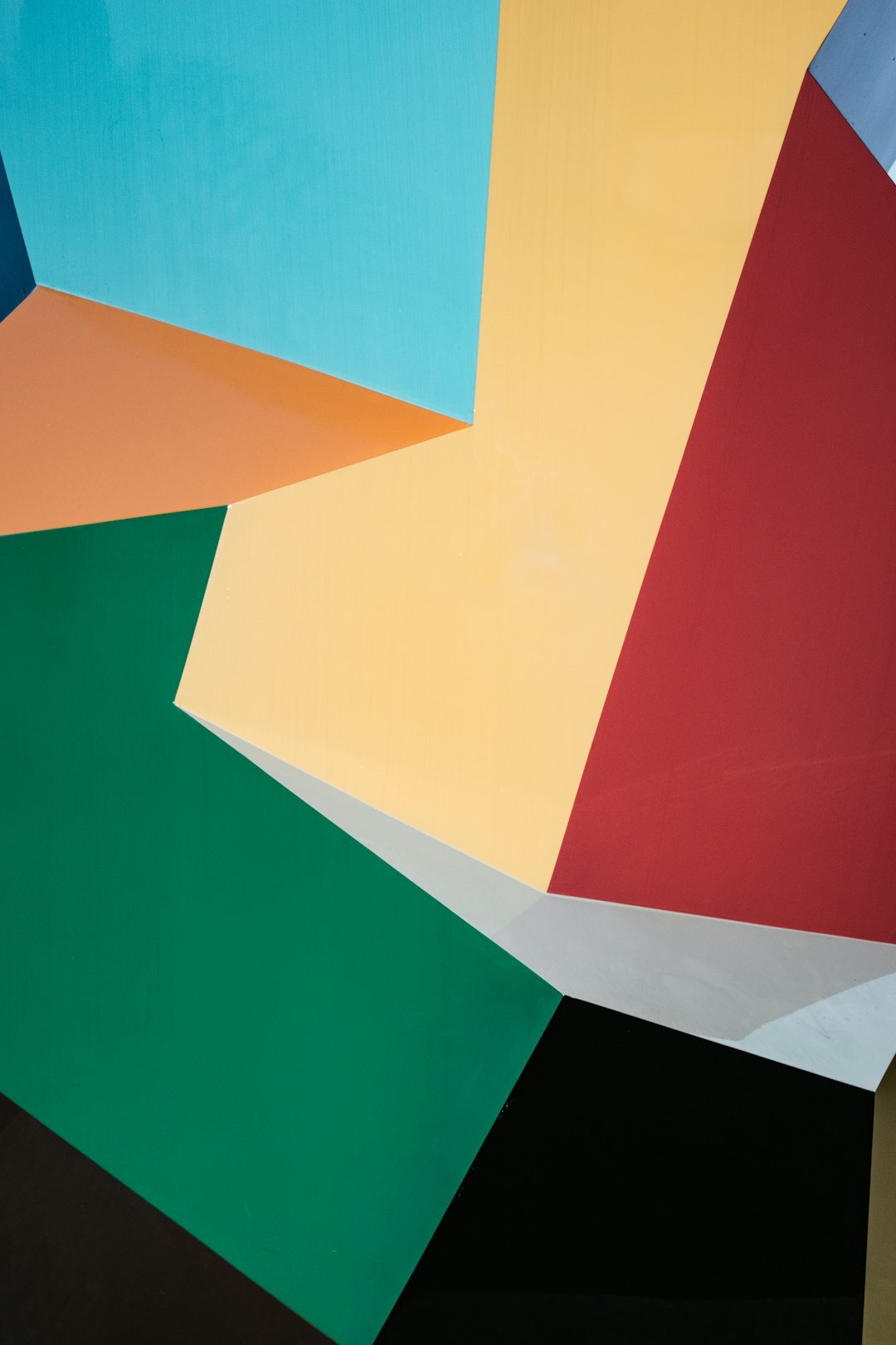 Teal, orange, green, and yellow polygons form a modern geometric pattern.